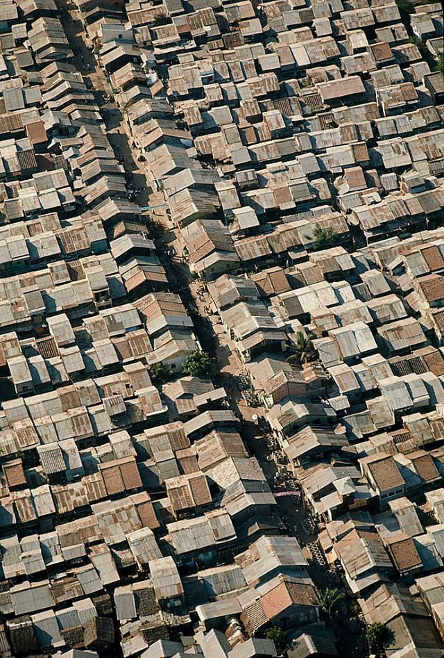 #32 Shacks made of metal, wood, and cardboard jam a Saigon suburb, Cholon, 1965