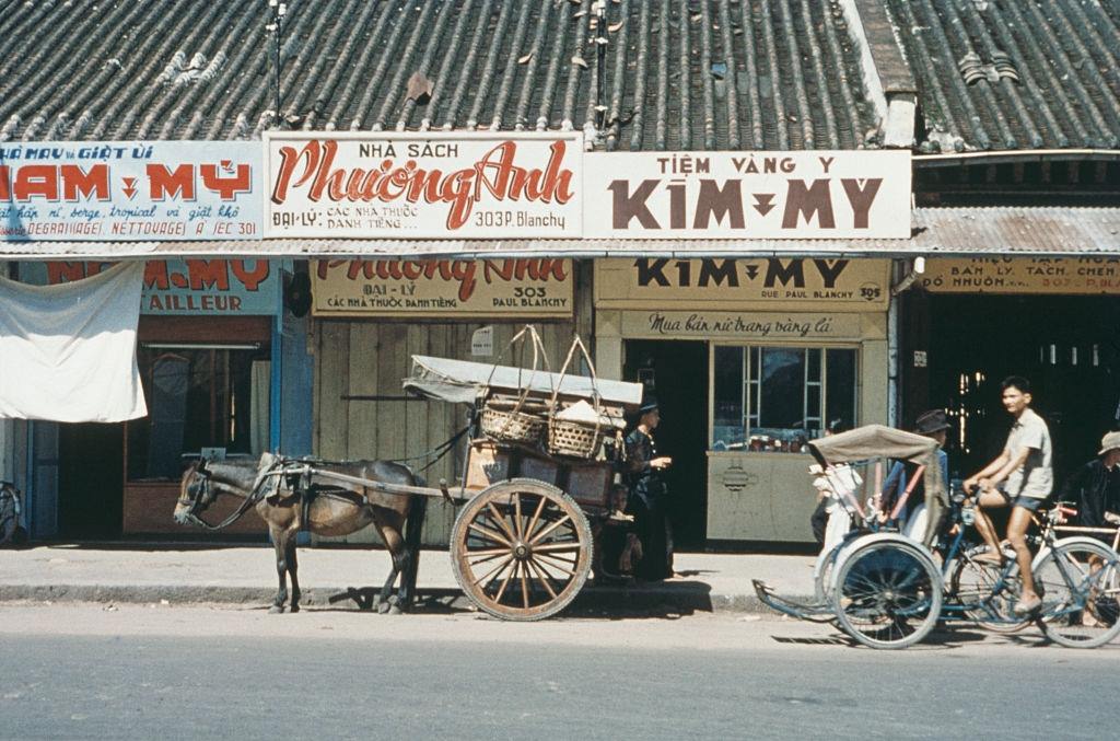 #64 A view of shops on a street in Saigon, 1960.