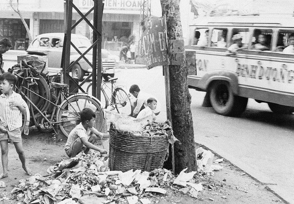 #64 Young Vietnamese children search a garbage dump to try to find something to sell or eat, July 30, 1965