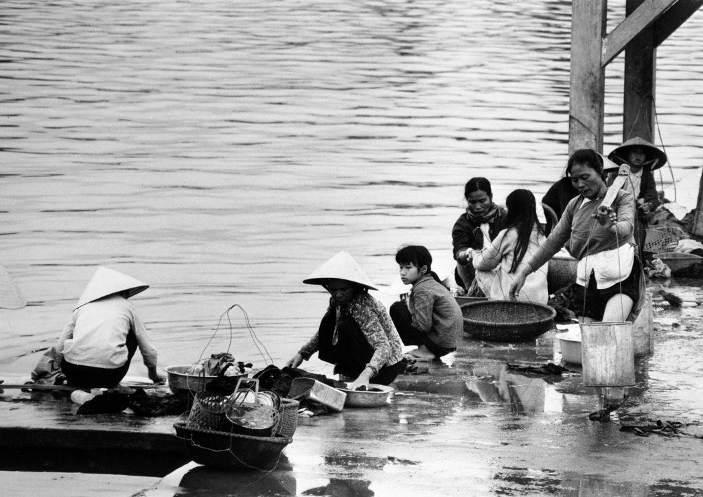#69 On the edge of the Perfume River, women do laundry in Hue, Vietnam on April 12, 1968.