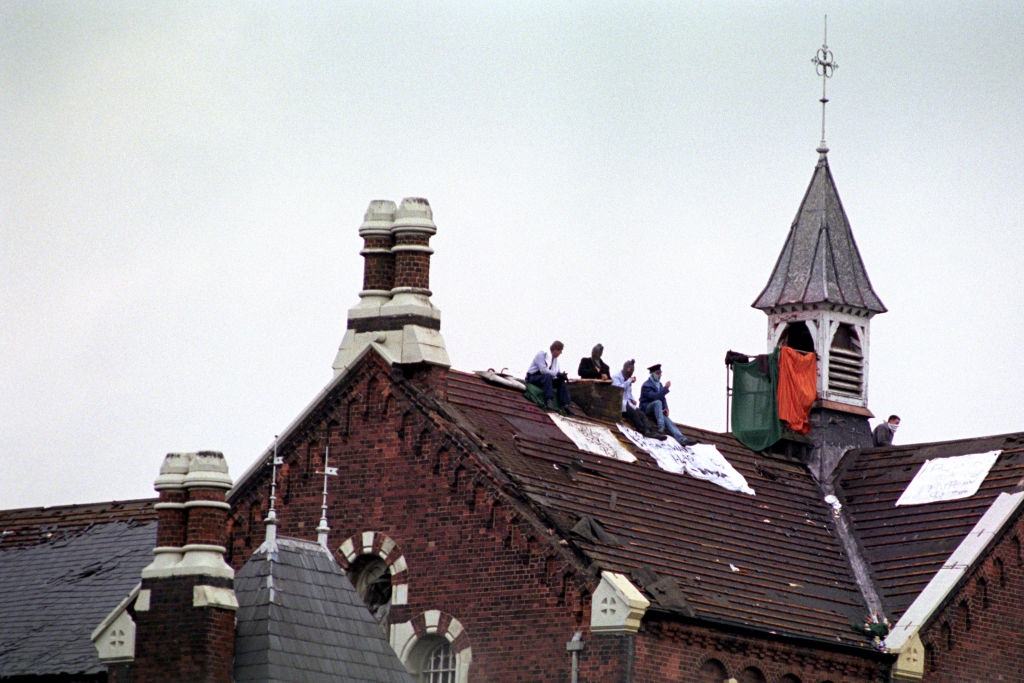 #25 Prisoners on the roof of Strangeways Prison in Manchester during the riot, 1990.