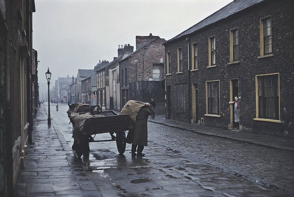 #13 A man delivering sacks of coal from a horse and cart, Belfast, 1955.