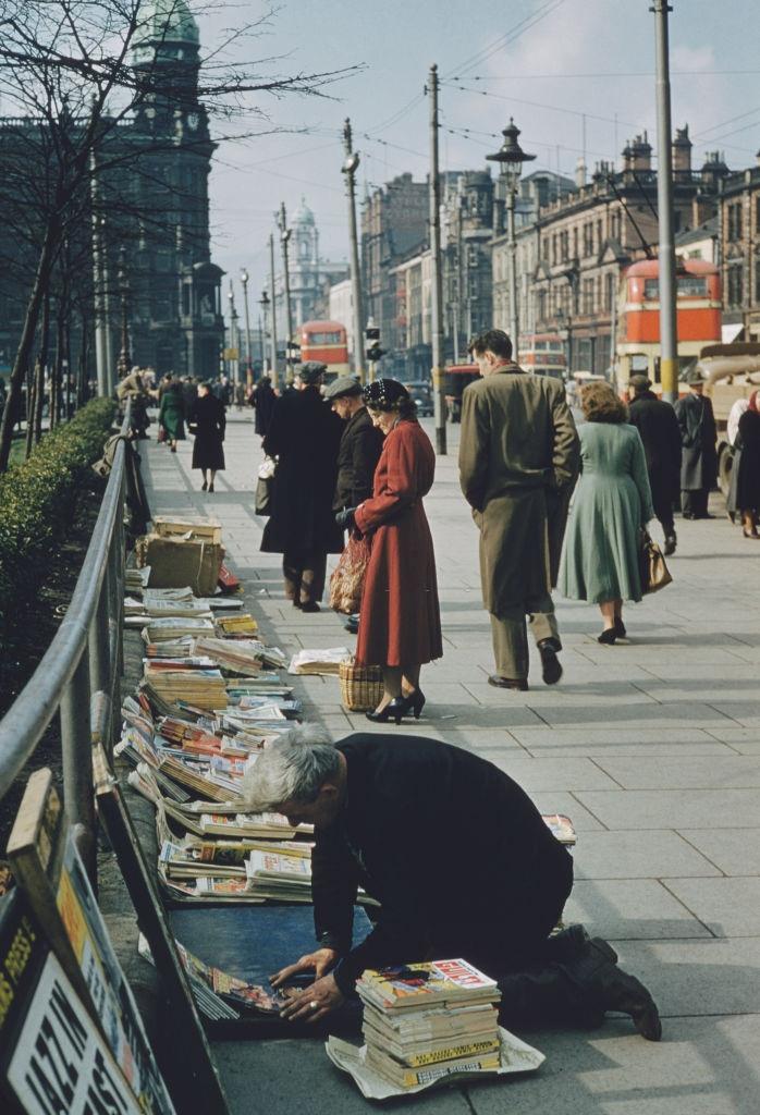 #1 A man selling books and magazines in the street in Belfast, 1955.