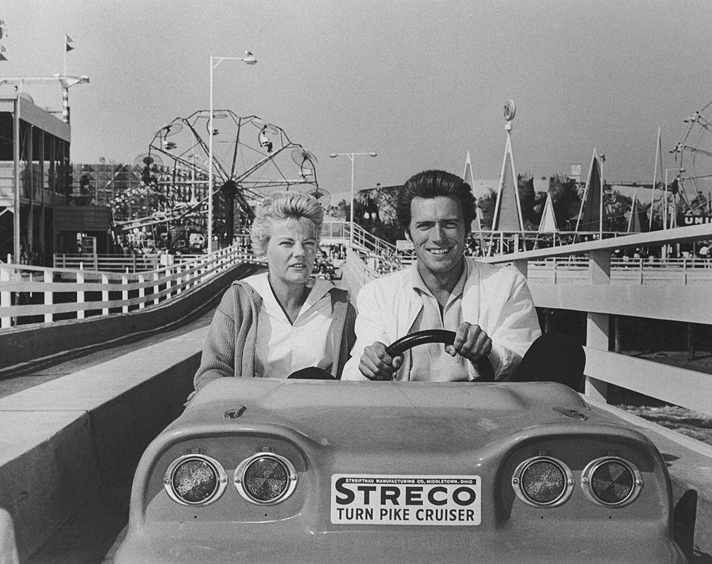 #13 Clint Eastwood sits behind the wheel as he and his wife Maggie take a ride on the Union 76 Ocean Highway at Pacific Ocean Park, 1959.