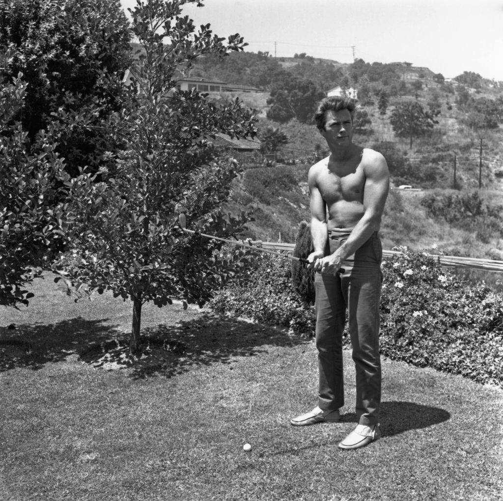 #21 Clint Eastwood playing golf at his home in the Hollywood Hills, 1960.