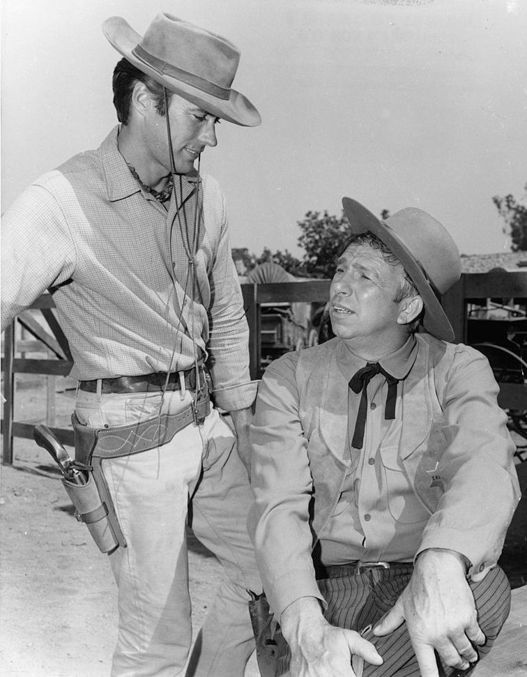 #24 Clint Eastwood talks with Slim Pickens during a break from shooting the television series ‘Rawhide’, 1960.
