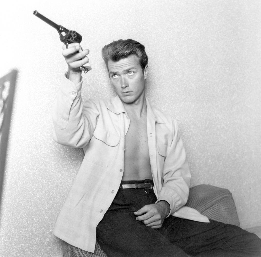 #5 Clint Eastwood checks his gun at home on June 1, 1956.