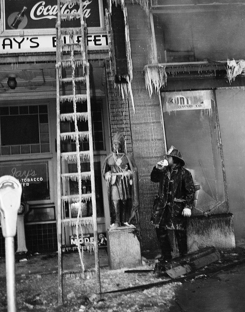 #17 Firefighter looking at frozen ladder, 1900s.