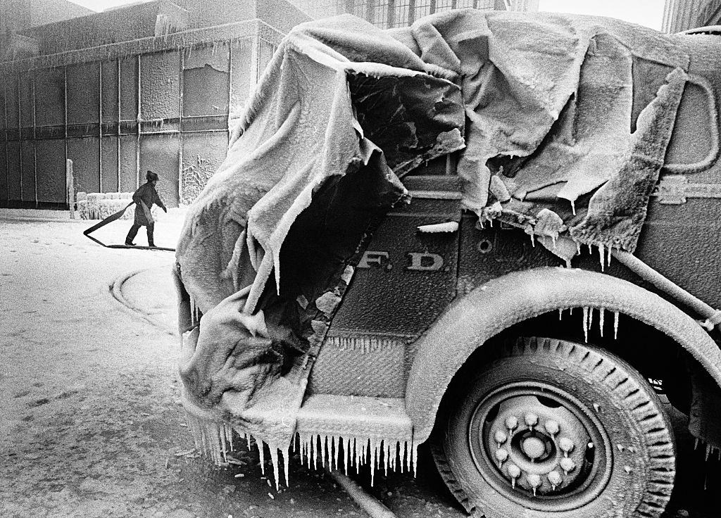 #30 A firefighter carries a hose between an ice-covered fire engine and burning buildings in downtown Minneapolis on Thanksgiving Day, 1982.