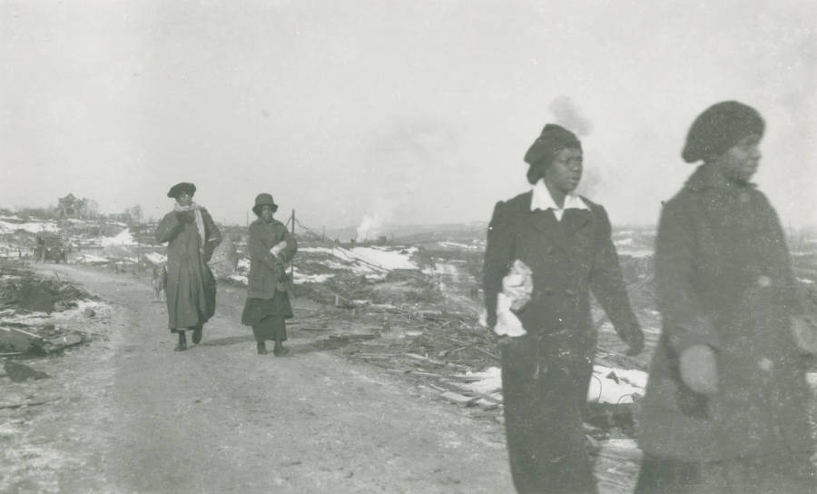 #10 Women from Africville, the black district of Halifax, make their way through the rubble.