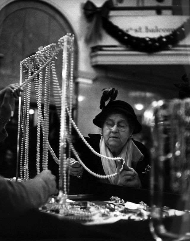 #9 A customer examining a string of pearls.