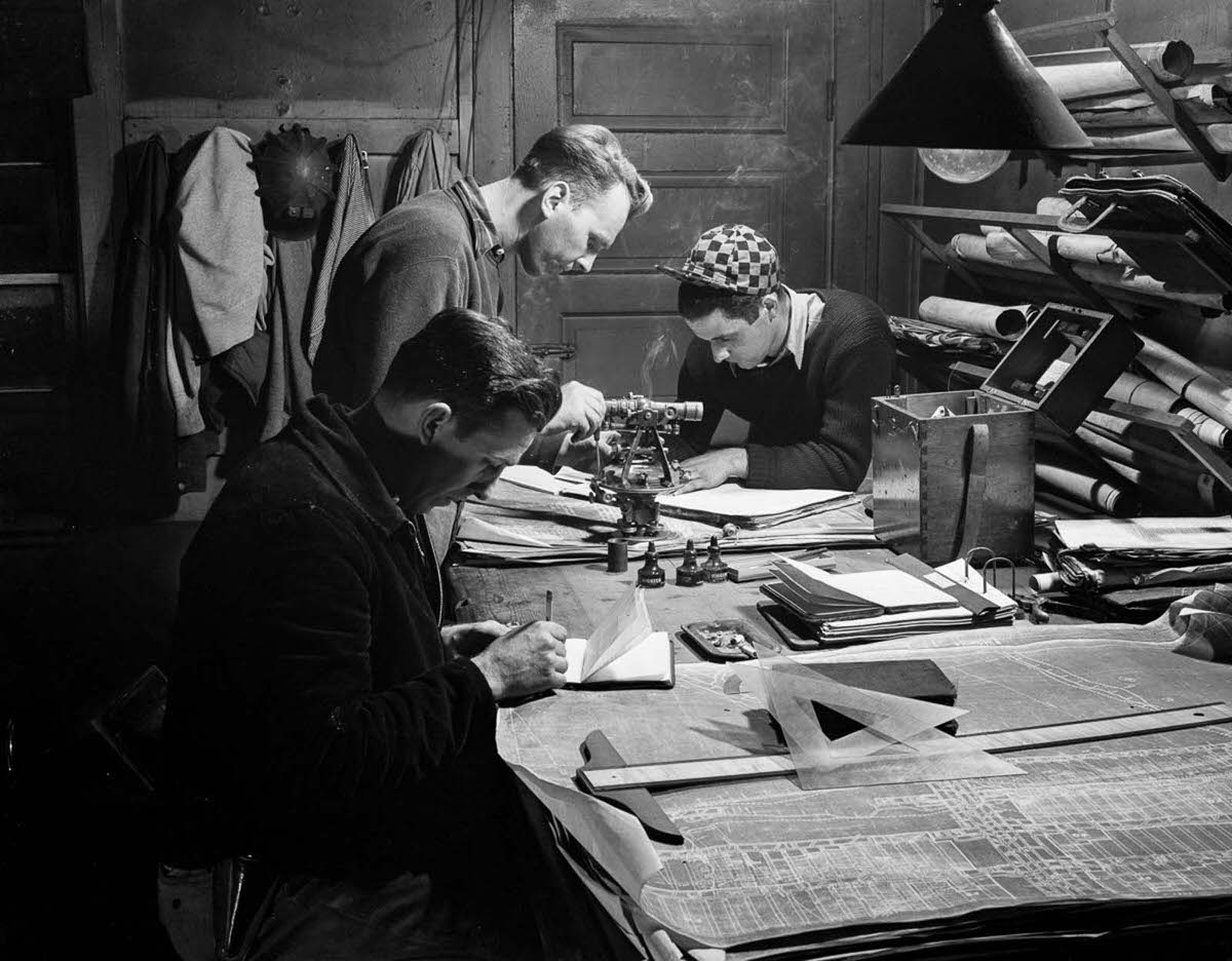 #18 Mine engineers check surveys after a day’s work.