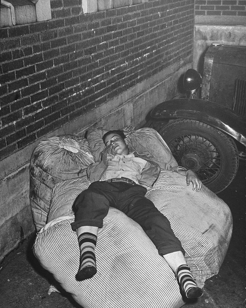 #19 A boy sleeping while waiting for the bus to arrive in the depot, Salt Lake City, 1945.