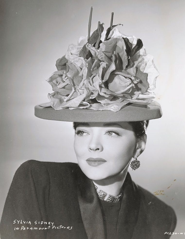#80 Sylvia Sidney wearing hat made with paper flowers, 1946.