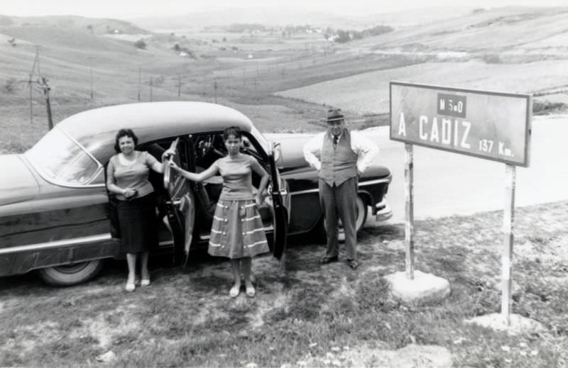 #29 Three members of a Spanish middle-class family posing with a 1952 Oldsmobile 98 on N-340, the highway running along Spain’s southern coastline from Barcelona to Cádiz, 1955