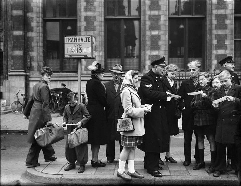 #19 The police distribute pamphlets to the youth within the framework of the ‘anti-tram-bunch-action’, Nieuwezijds Voorburgwal. Amsterdam, December 14, 1946.