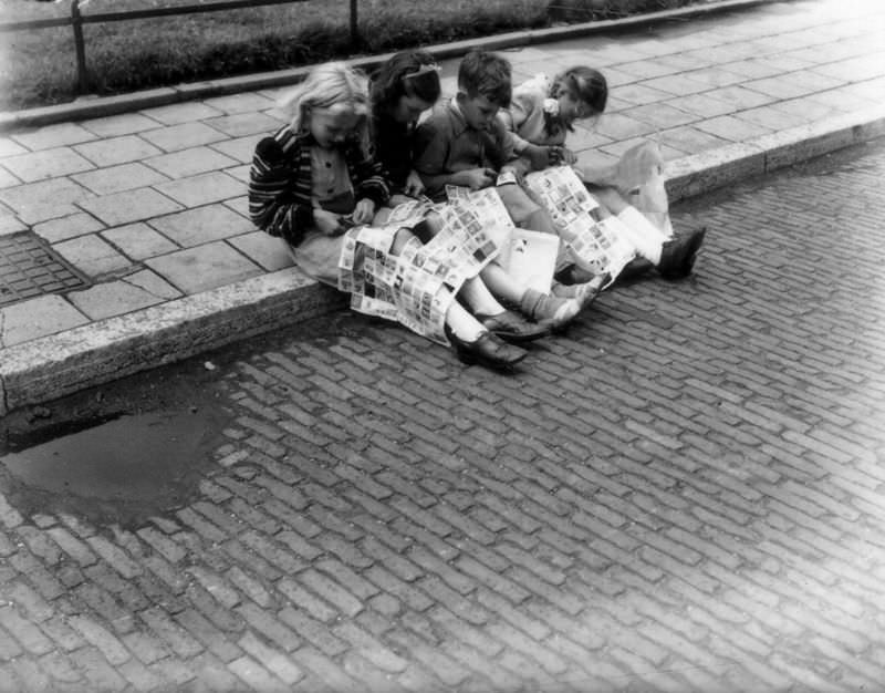 #21 Children on the sidewalk with large sheets of advertising stamps, July 9, 1947