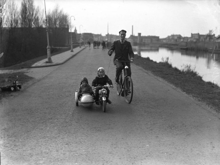 #1 Children on miniature motorcycle with sidecar under the guidance of their father, 1946