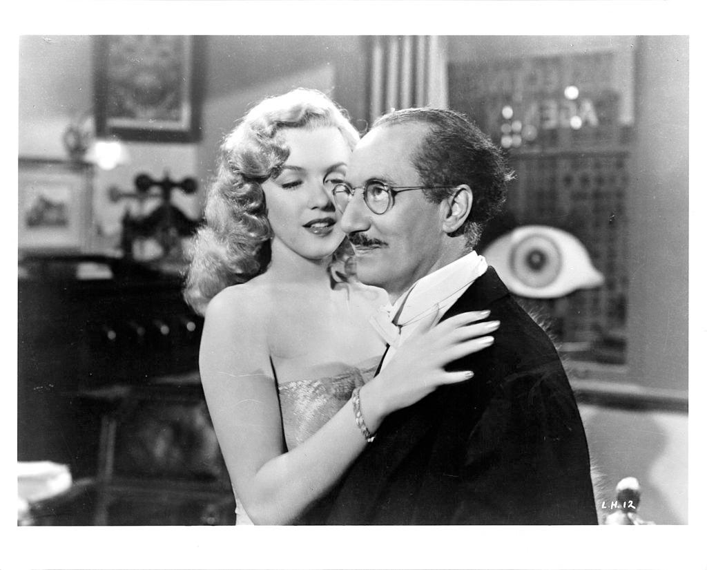 Marilyn Monroe embraces Groucho Marx in a scene from the film ‘Love Happy’, 1949.