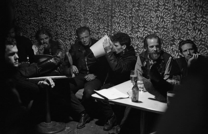 #12 A member of the Hells Angels’ drinking beer from a plastic container.