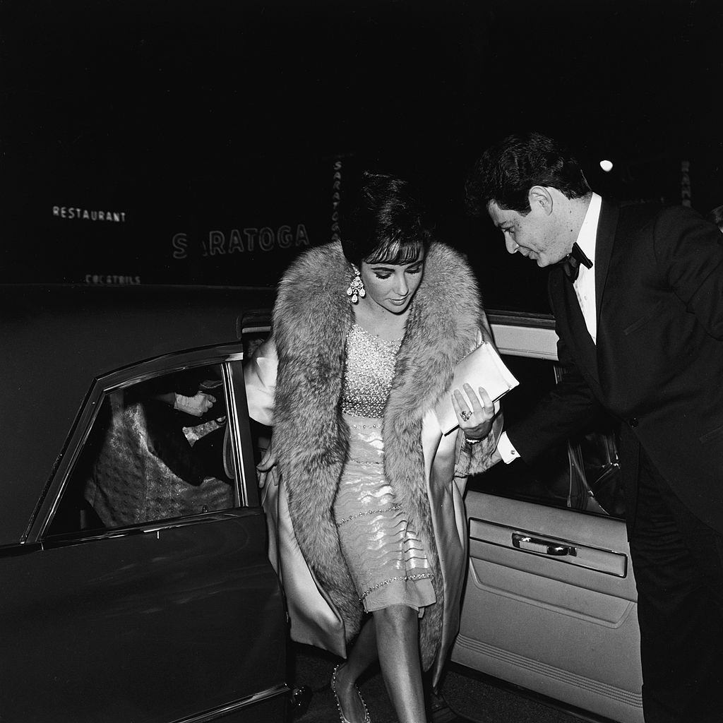 Elizabeth Taylor steps from a car, escorted by her husband Eddie Fisher as they arrive at the premiere of the film, ‘Suddenly Last Summer,’ 1959.