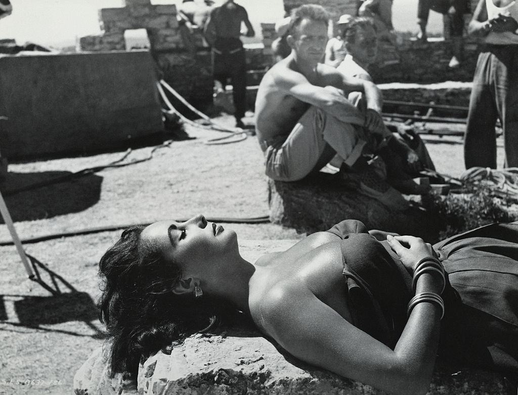 Elizabeth Taylor makes a lovely picture in this candid shot, sunning herself in Spain on location for “Suddenly Last Summer.”