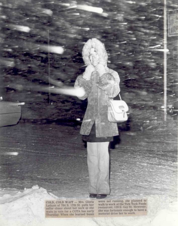 #34 A woman pulls her collar closer about her neck as she waits in vain for a COTA bus early Thursday.