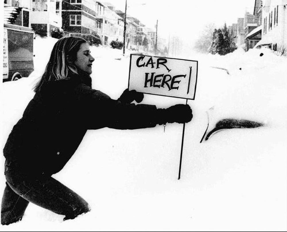 #6 Bonnie Alexandre, of Boston’s Brighton district, attaches a sign to the antenna of her car in Boston
