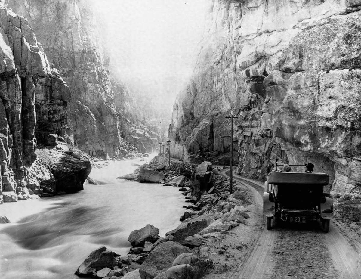 #12 Tourists drive their car on a dirt road along the Yellowstone River, 1899.