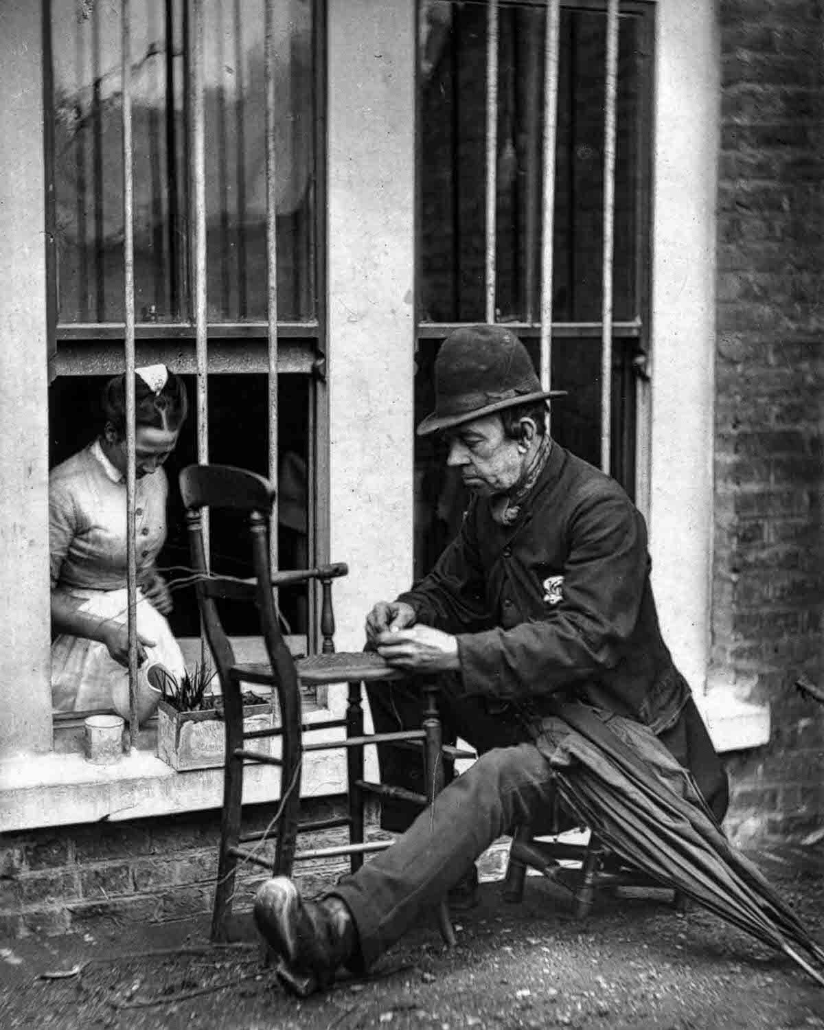 #16 Caney” the clown weaves cane strips into the seat of a wooden chair, 1877.
