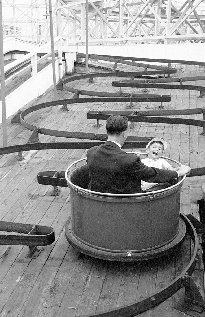 #15 A father and son enjoying a fairground ride on the pleasure beach at Blackpool, 1953.