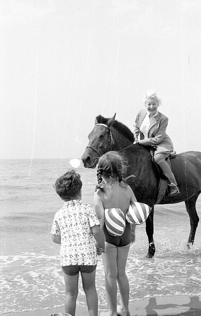 #16 Marianne Lincoln, who will compere the ‘Stars At Blackpool’ television show, enjoying a horse ride on the beach where she meets two young fans, 1953.