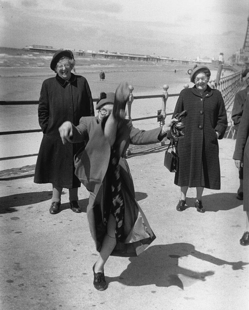 #43 An elderly women performs a high kick on the promenade at Blackpool, 1955