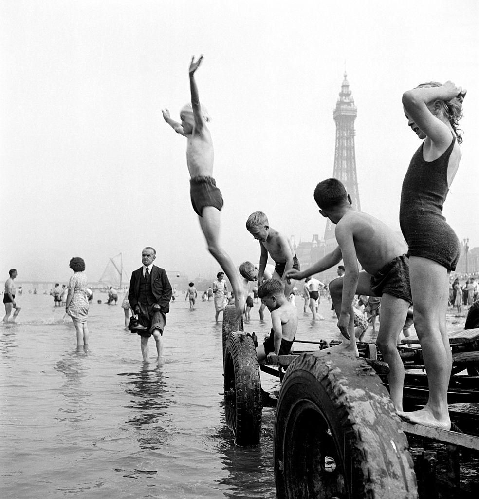 #46 Children in swimming costumes jump into the sea, Blackpool, 1955.
