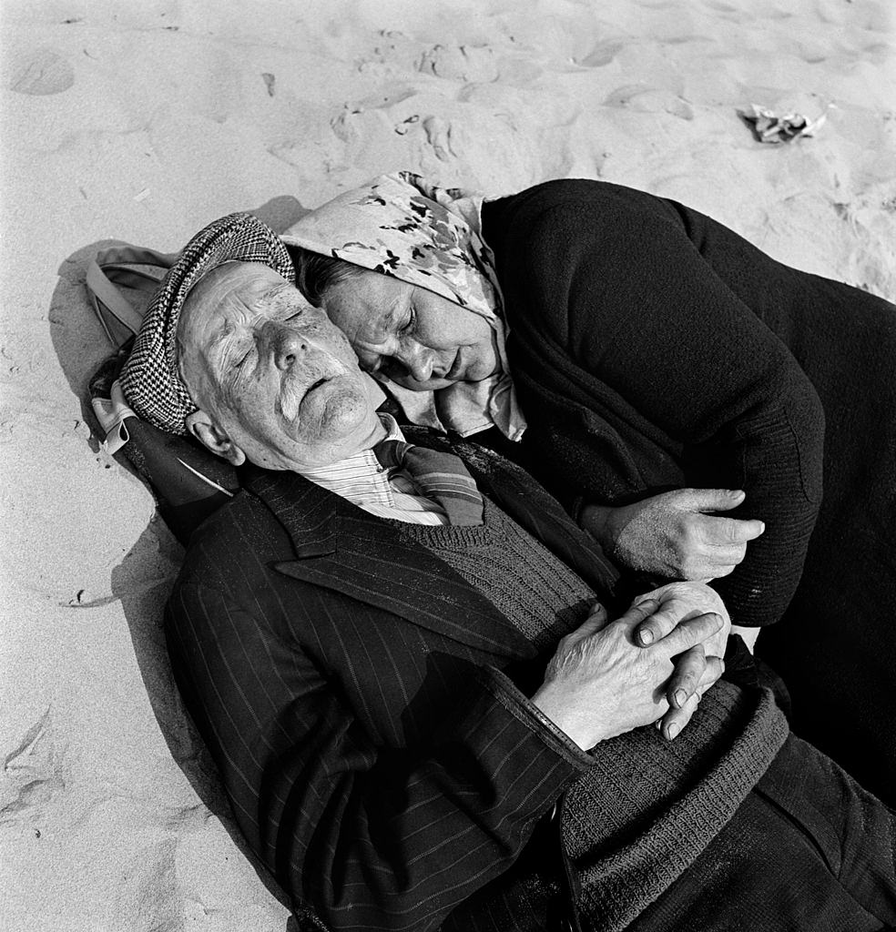 #41 An elderly couple doze on the Blackpool beach, 1955.