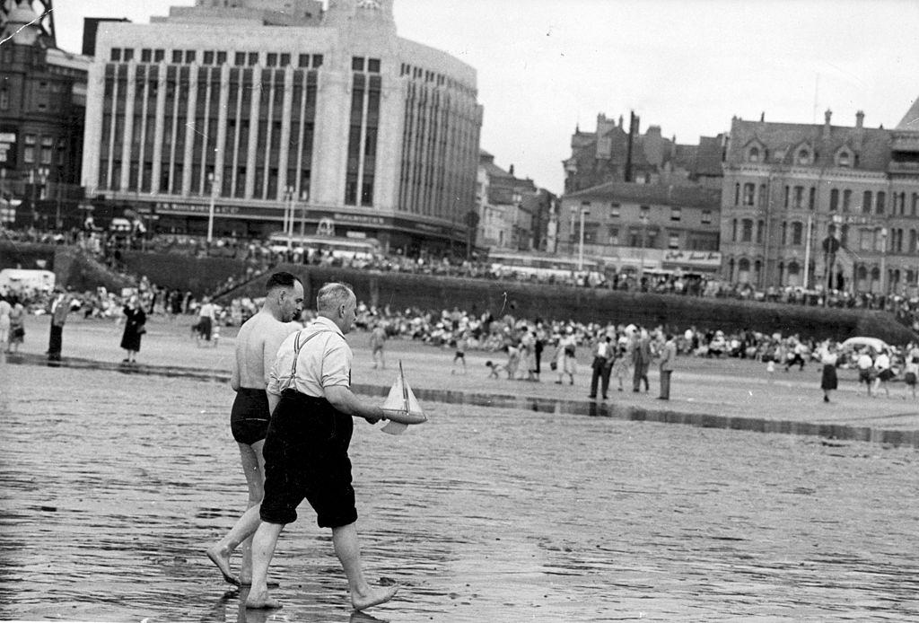 #53 Two men with their toy boat on the beach at Blackpool, July 1956.
