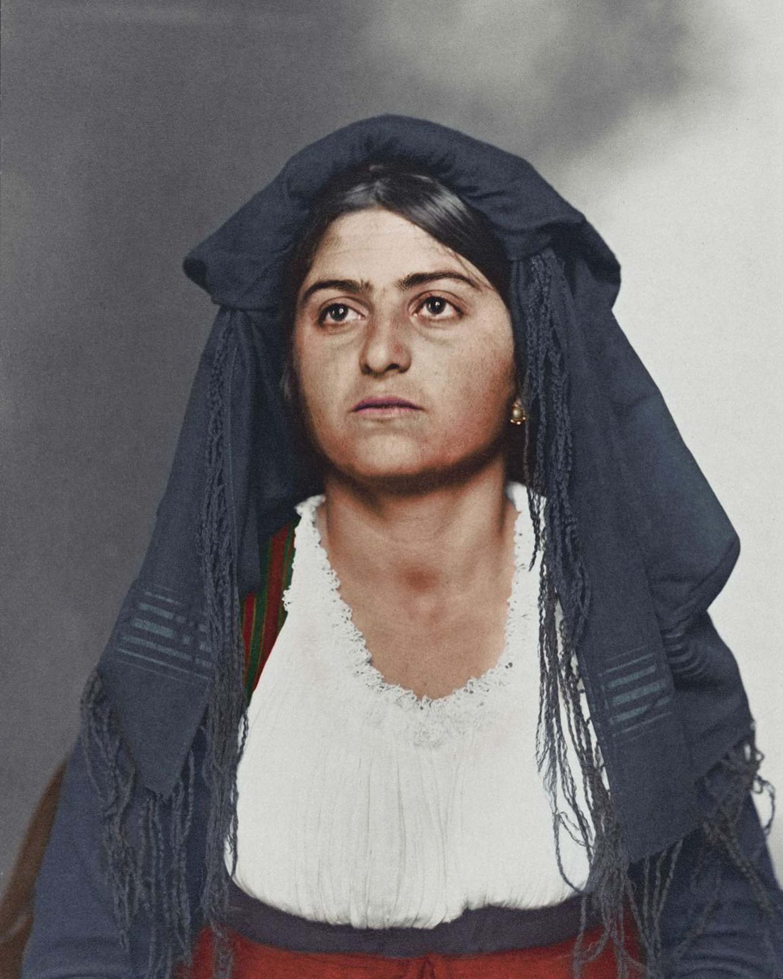 #12 Italian woman.” This traditional dress was most likely homespun and consisted of a long, wide dress to cover the ankles. Above, a bodice and sleeves were tied in such a way to expose portions of the linen blouse. Colors and materials were usually regional. Shawls and veils were also a common feature