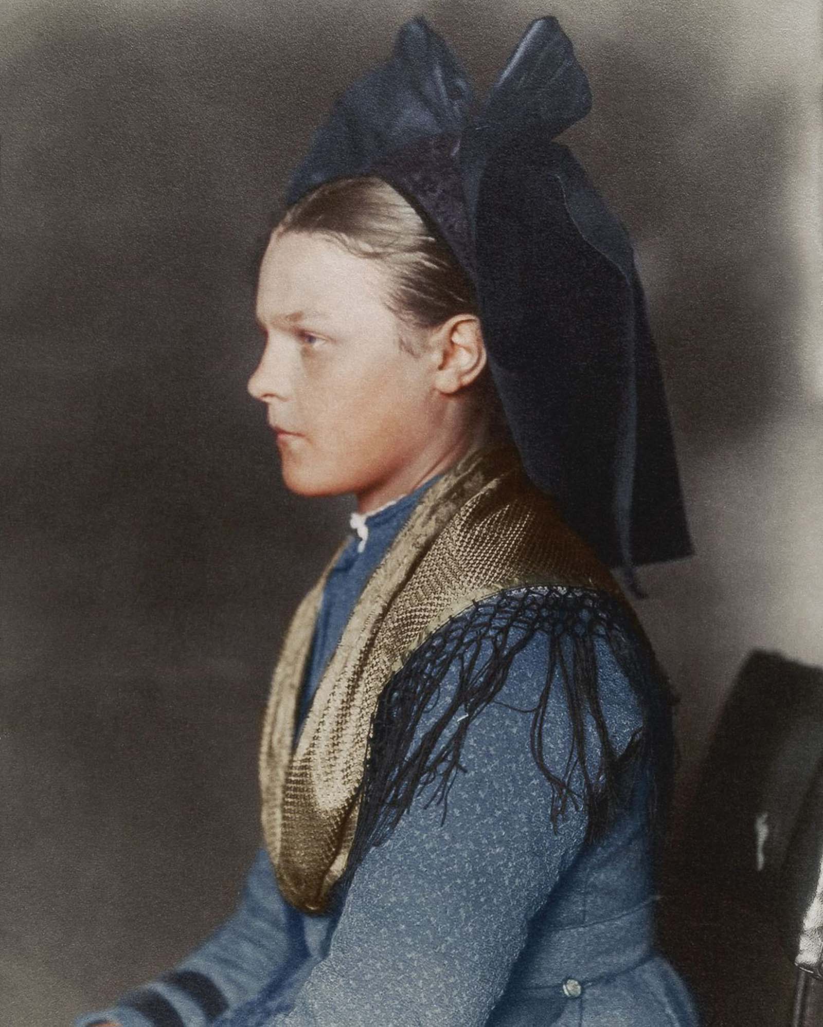 #15 Alsace-Lorraine girl.” This girl hails from the Germanic speaking region of Alsace, now in modern day France. The large bow, known as a schlupfkàpp, was worn by single women, and signified the wearer’s religion: Protestants wore black while Catholics favored brightly colored bows. 1906.