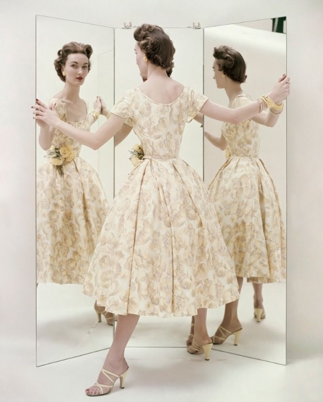 #9 Evelyn Tripp wearing a pale yellow summer party dress by Kane, with matching mules by Valley, 1954
