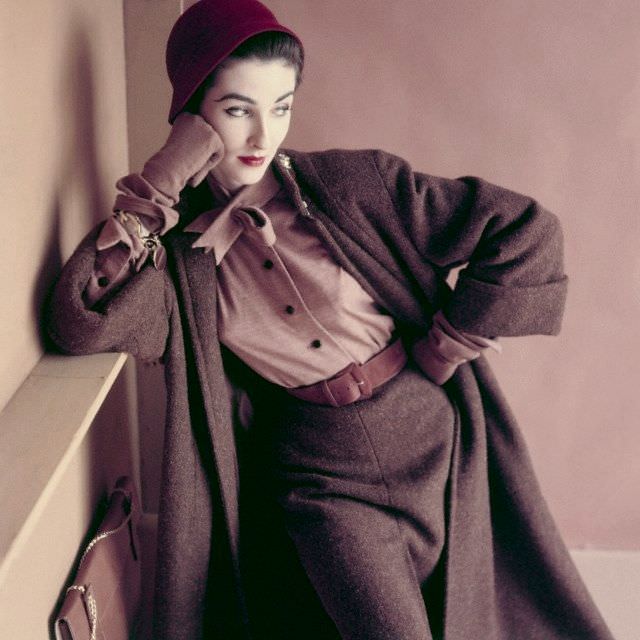 #3 Model is wearing a slim tweed coat, a matching skirt with a single walking pleat, and wool jersey blouse with neckline tie, matching gloves and raspberry cloche hat, 1952