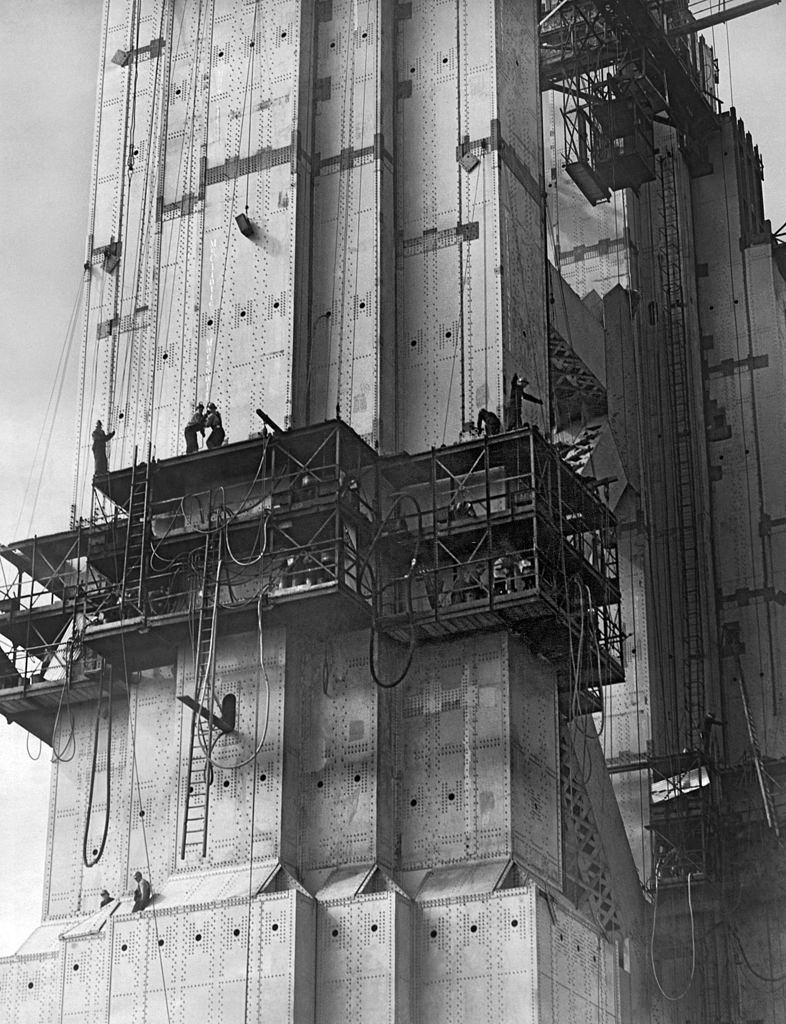 #2 The Golden Gate Bridge under construction with riveters at work in cages on the South Tower, 1935.