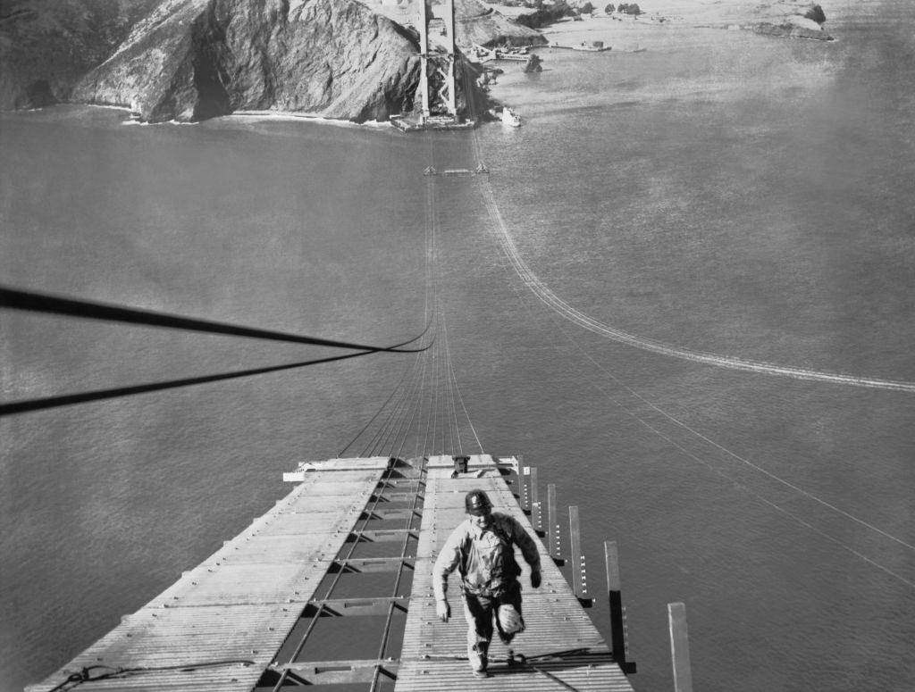 #24 A worker running up one of the catwalks being built for the construction of the cable of the Golden Gate Bridge.