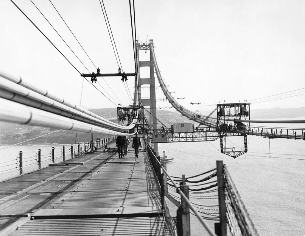 #31 Construction of the Golden Gate Bridge with a view of the catwalks being placed under the cables, 1936.