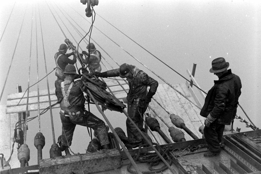 #42 Men standing on a platform during the construction of the Golden Gate Bridge in San Francisco.