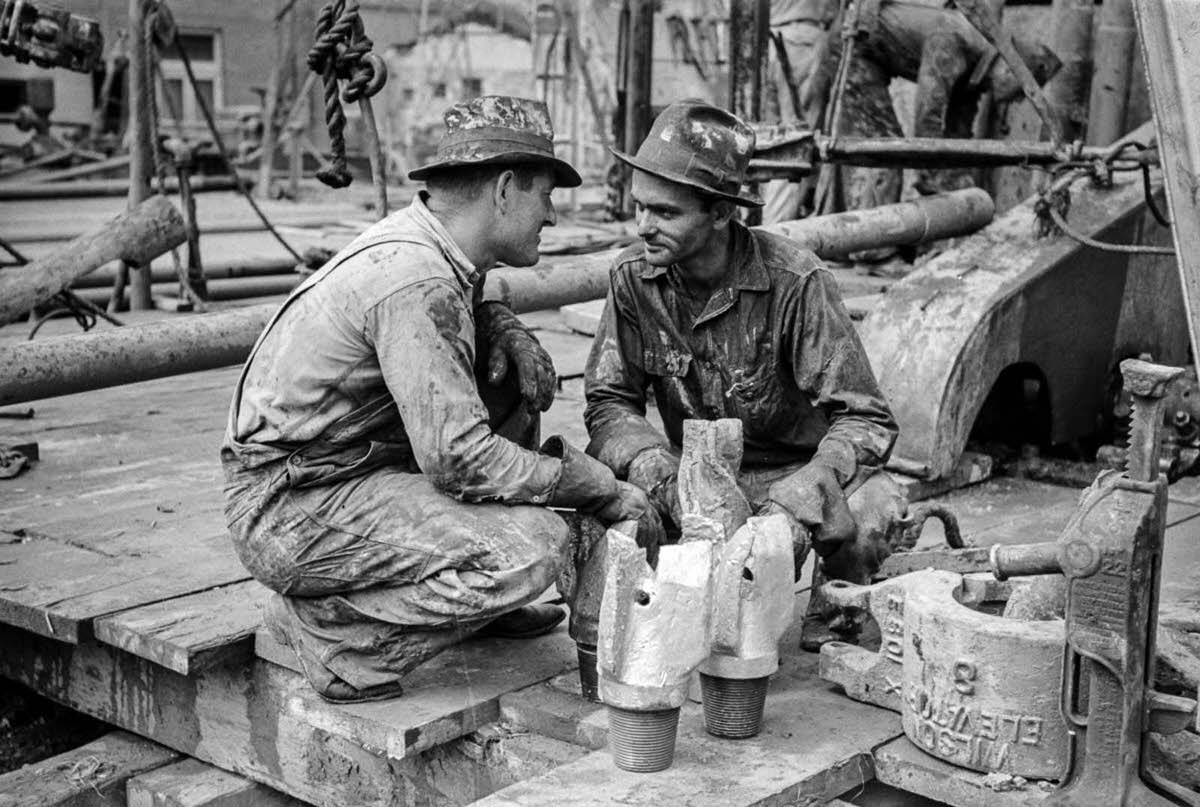 #27 Workers confer over drill bits.