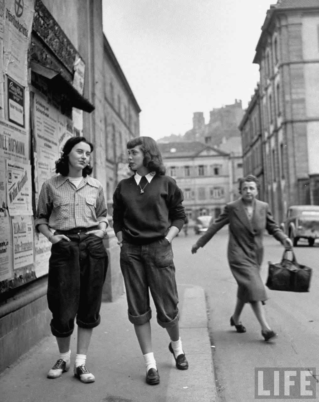 #4 Two American students sauntering along a Heidelberg street, cause staid German women to look at them in wonderment.