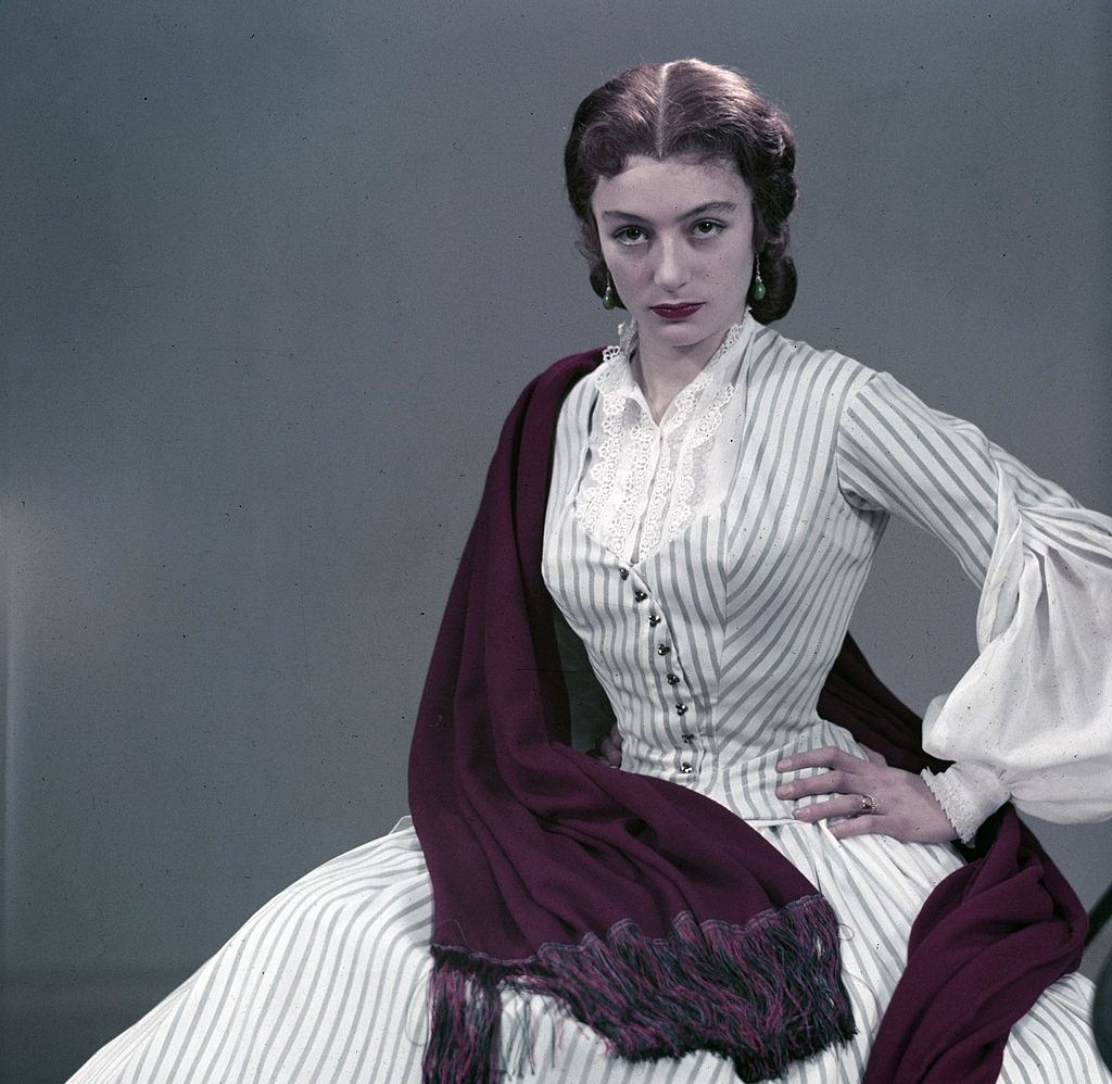 #7 Anouk Aimée in long dress, purple shawl over her shoulder, 1953.