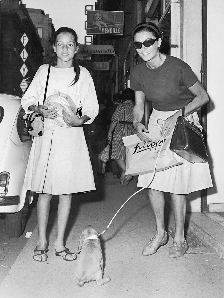 #51 Anouk Aimée with her puppy and a girl, 1980s.