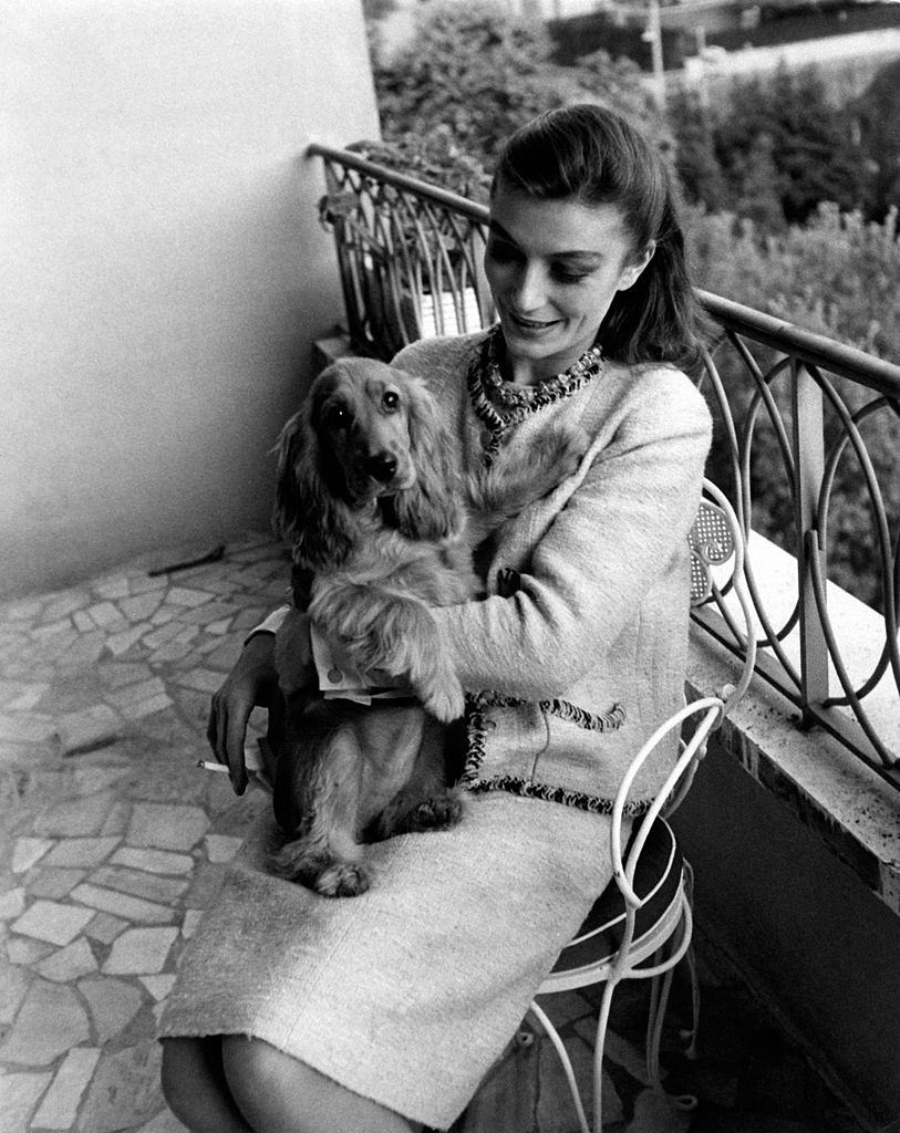 #14 Anouk Aimée sitting in the balcony with her female dog Lulù in her arms in her home in Rome, 1963.