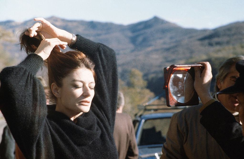 #19 Anouk Aimée fixing her hair in front of a mirror, 1975.